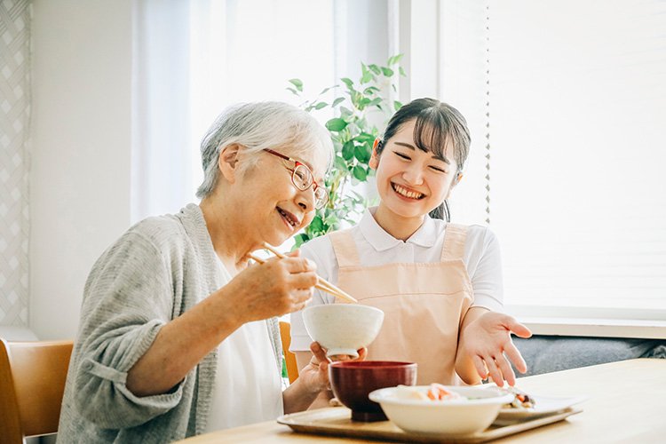 笑顔で食べる人と見守る従業員